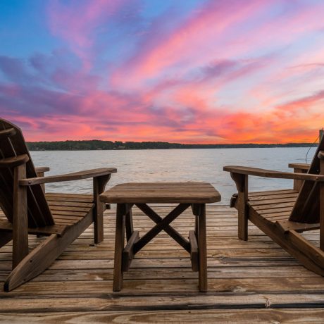 lounge chairs overlooking lake and colorful sky